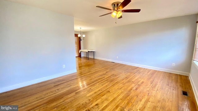8107 Candle Ln, Baltimore, MD 21237 - unfurnished room featuring baseboards, light wood finished floors, visible vents, and ceiling fan with notable chandelier