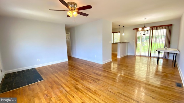 8107 Candle Ln, Baltimore, MD 21237 - spare room with baseboards, ceiling fan with notable chandelier, visible vents, and light wood-type flooring