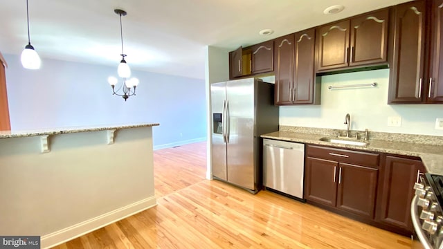 8107 Candle Ln, Baltimore, MD 21237 - kitchen featuring stainless steel appliances, dark brown cabinets, a sink, light wood-style floors, and light stone countertops