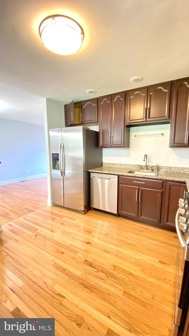 8107 Candle Ln, Baltimore, MD 21237 - kitchen featuring dark brown cabinetry, stainless steel appliances, a sink, and light wood finished floors