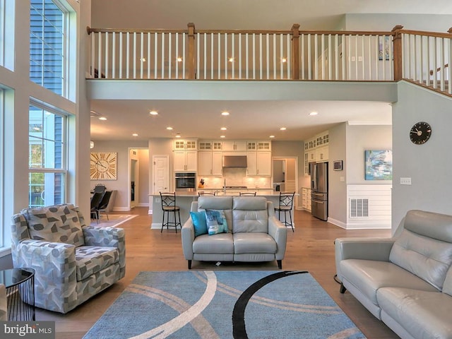22144 Welches Way, Lewes, DE 19958 - living area featuring a towering ceiling, wood finished floors, baseboards, and recessed lighting