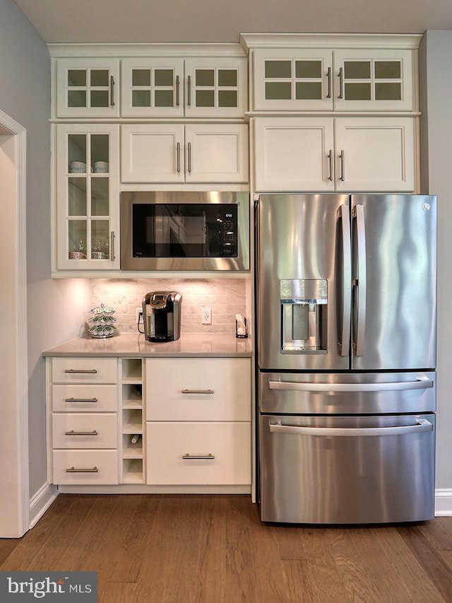 22144 Welches Way, Lewes, DE 19958 - kitchen featuring stainless steel fridge with ice dispenser, built in microwave, light countertops, decorative backsplash, and white cabinets