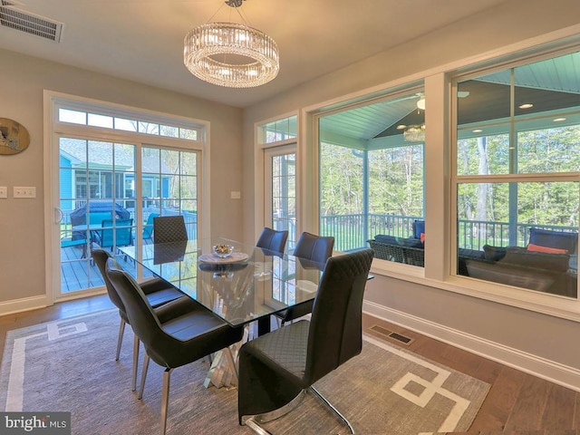 22144 Welches Way, Lewes, DE 19958 - dining space with baseboards, wood finished floors, a chandelier, and healthy amount of natural light