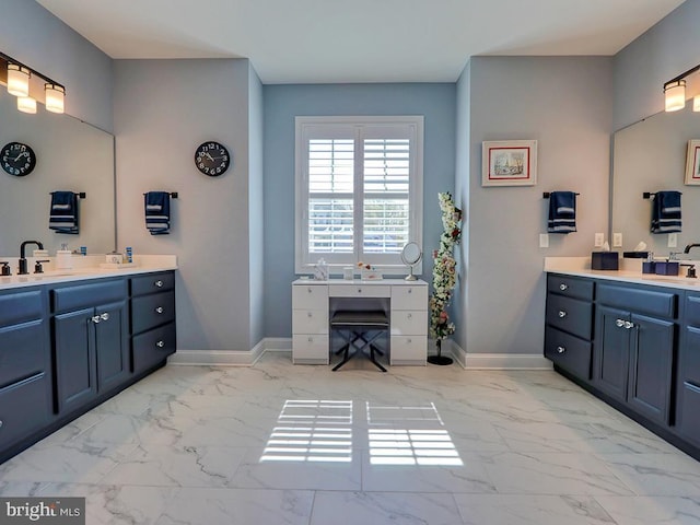 full bath with marble finish floors, two vanities, and baseboards