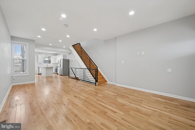 3024 Redner St, Philadelphia, PA 19121 - unfurnished living room with recessed lighting, a sink, light wood-type flooring, baseboards, and stairs