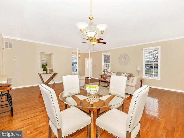 dining area featuring a chandelier, visible vents, light wood finished floors, and ornamental molding