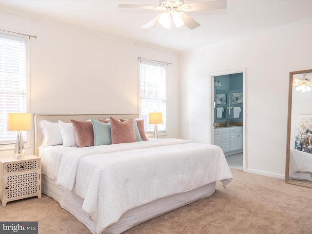 bedroom with ceiling fan, ensuite bath, ornamental molding, and light colored carpet