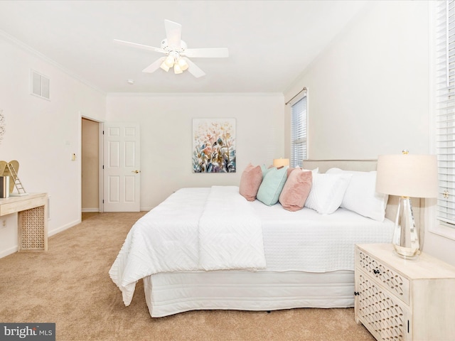 carpeted bedroom with ceiling fan, visible vents, baseboards, and ornamental molding