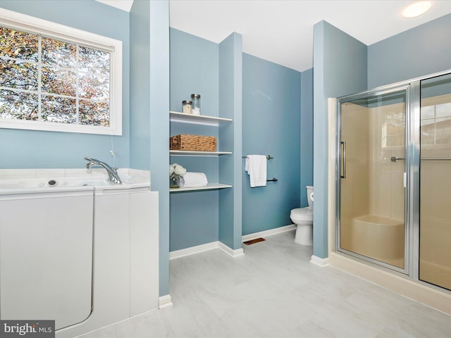 bathroom featuring a shower stall, a garden tub, toilet, and baseboards