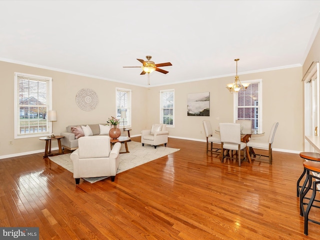 living room featuring wood-type flooring, baseboards, crown molding, and plenty of natural light