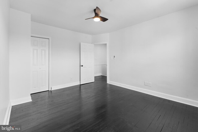 unfurnished bedroom with baseboards, dark wood finished floors, and a closet