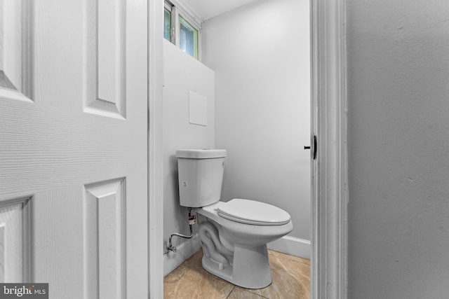 bathroom with toilet and baseboards