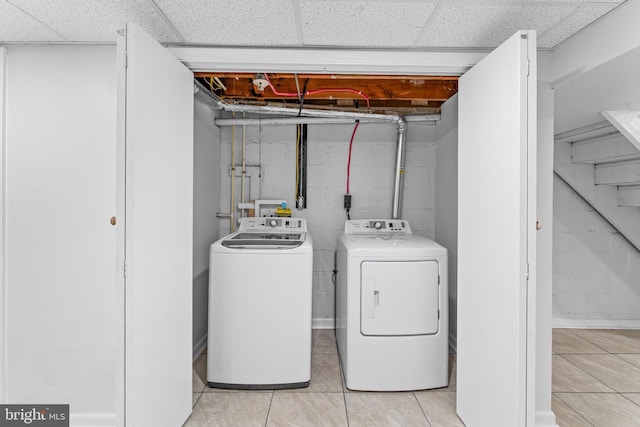 laundry room featuring separate washer and dryer and light tile patterned flooring
