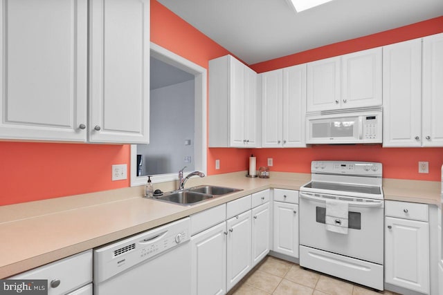 kitchen featuring a sink, light countertops, white cabinets, light tile patterned floors, and white appliances