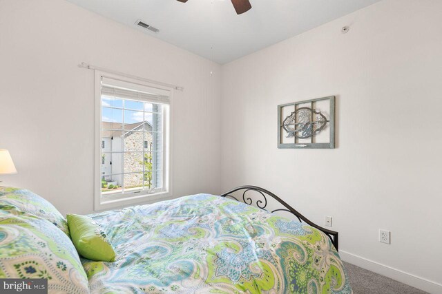 carpeted bedroom featuring visible vents, a ceiling fan, and baseboards