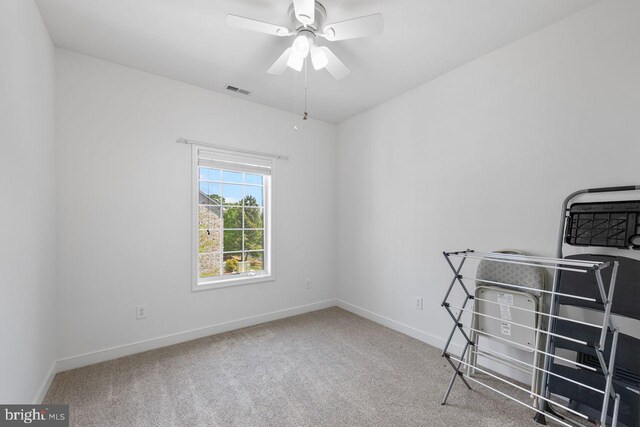 interior space with baseboards, carpet, a ceiling fan, and visible vents