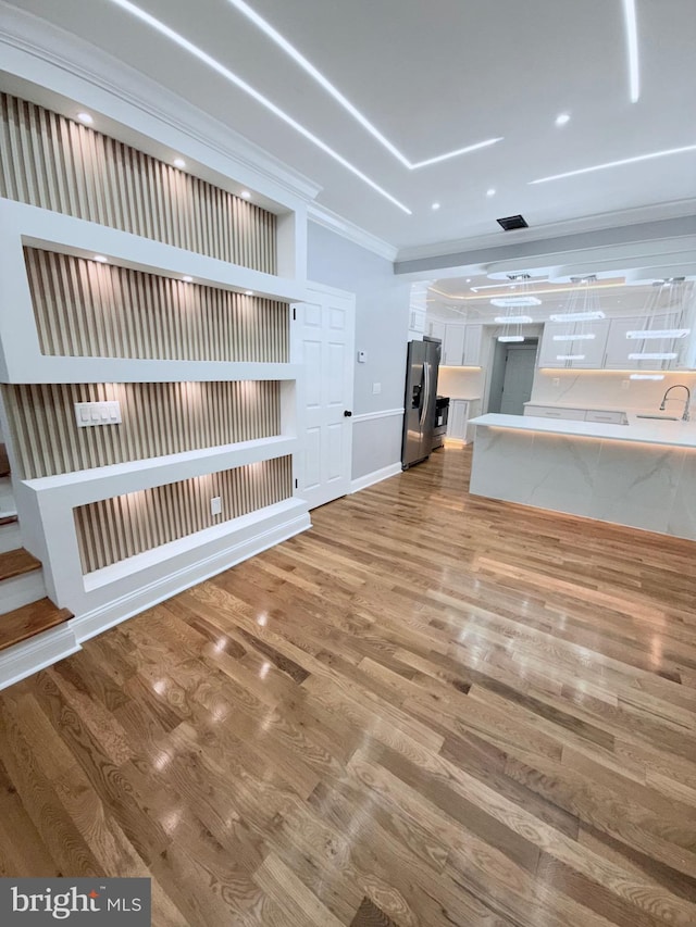 5441 Media St, Philadelphia, PA 19131 - unfurnished living room featuring recessed lighting, wood finished floors, a sink, crown molding, and baseboards