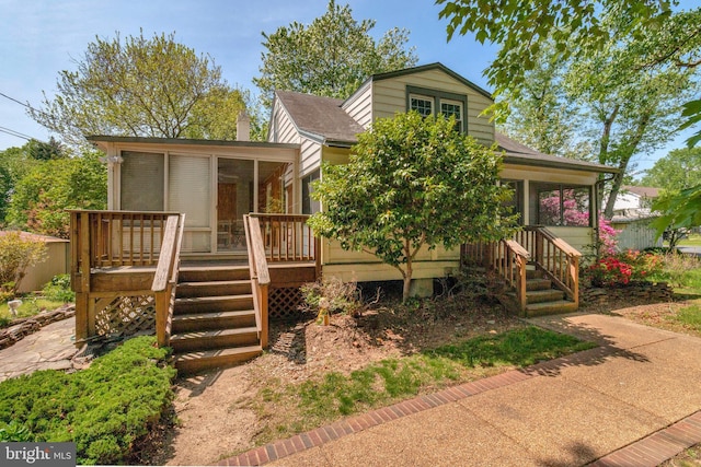 6230 Valley View Dr, Alexandria, VA 22310 - view of front of property with a wooden deck, a chimney, a sunroom, a shingled roof, and stairway