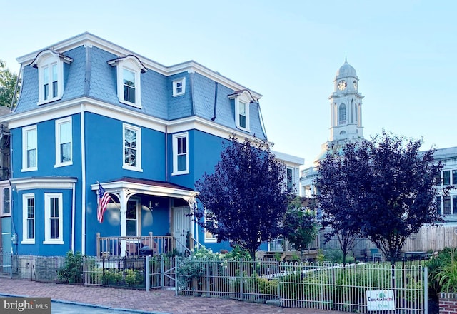 20-22 W Harvey St, Philadelphia, PA 19144 - view of front of house with mansard roof, a fenced front yard, covered porch, and stucco siding