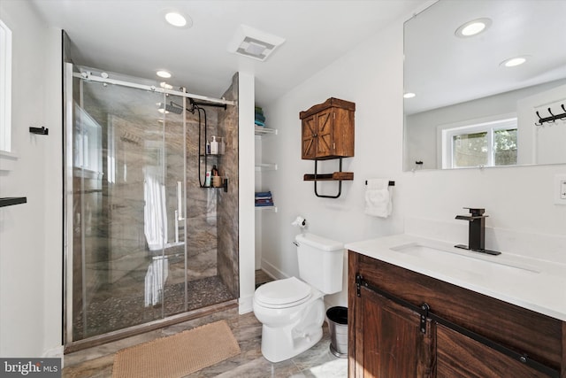 bathroom featuring toilet, recessed lighting, vanity, and a stall shower