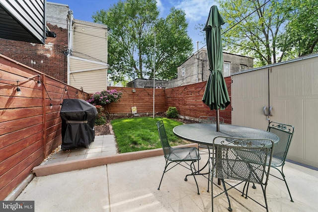 view of patio with a fenced backyard, a grill, and outdoor dining area