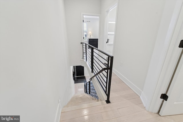 stairs featuring wood finished floors and baseboards