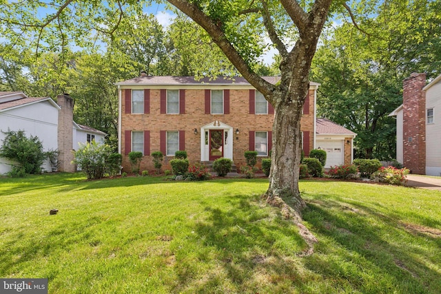 15915 Marlington Dr, Dumfries, VA 22025 - colonial-style house with brick siding, a front yard, and a garage