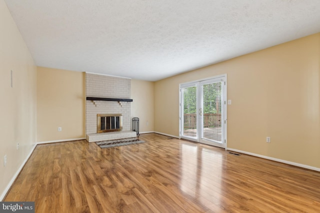15915 Marlington Dr, Dumfries, VA 22025 - unfurnished living room featuring wood finished floors, a fireplace, baseboards, and a textured ceiling