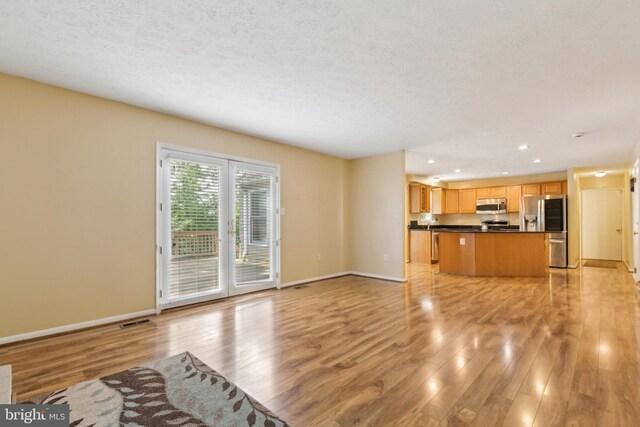 15915 Marlington Dr, Dumfries, VA 22025 - unfurnished living room featuring light wood-style floors, recessed lighting, baseboards, and a textured ceiling