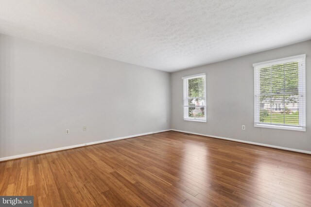 15915 Marlington Dr, Dumfries, VA 22025 - empty room with wood finished floors, baseboards, and a textured ceiling