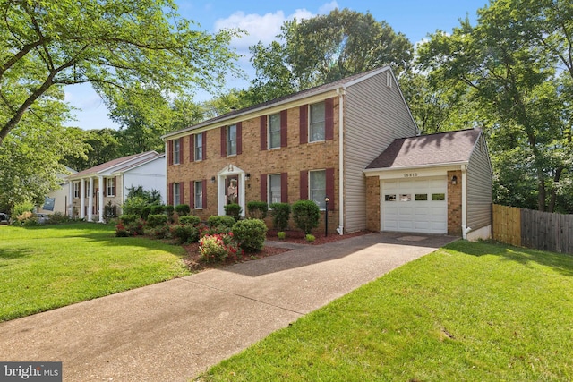 15915 Marlington Dr, Dumfries, VA 22025 - colonial inspired home featuring an attached garage, driveway, and brick siding