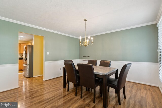 15915 Marlington Dr, Dumfries, VA 22025 - dining area with a chandelier, ornamental molding, wood finished floors, and baseboards