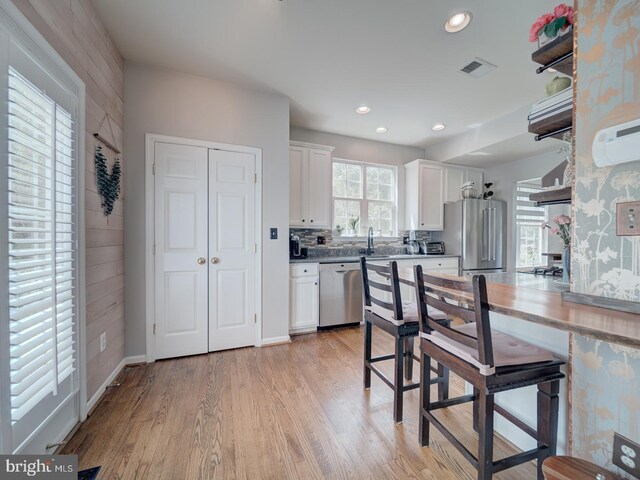 9477 Cromarty Ct, Bristow, VA 20136 - kitchen with white cabinets, appliances with stainless steel finishes, light wood finished floors, recessed lighting, and visible vents