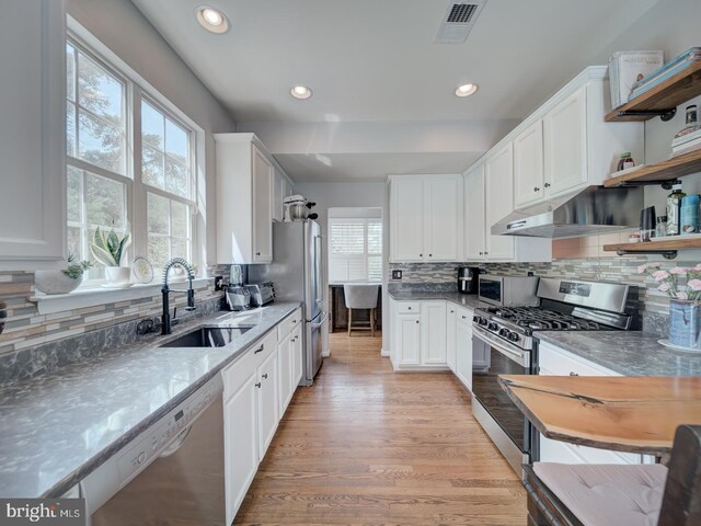 9477 Cromarty Ct, Bristow, VA 20136 - kitchen with open shelves, decorative backsplash, white cabinets, a sink, and appliances with stainless steel finishes