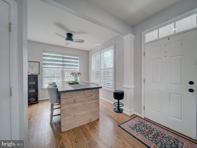 9477 Cromarty Ct, Bristow, VA 20136 - entrance foyer featuring baseboards, a ceiling fan, decorative columns, and light wood-type flooring