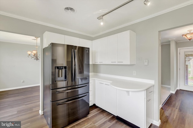 kitchen featuring white cabinets, wood finished floors, stainless steel fridge with ice dispenser, light countertops, and ornamental molding