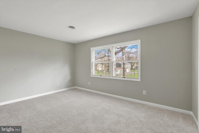 empty room with visible vents, baseboards, and carpet