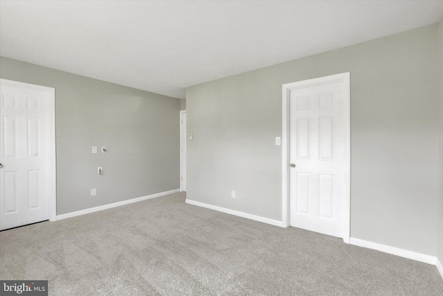 empty room featuring baseboards and carpet flooring