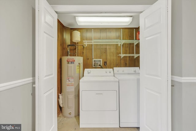 washroom with washing machine and clothes dryer, electric water heater, and laundry area