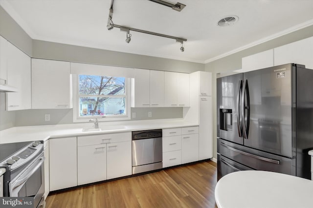 kitchen featuring visible vents, a sink, white cabinetry, and appliances with stainless steel finishes