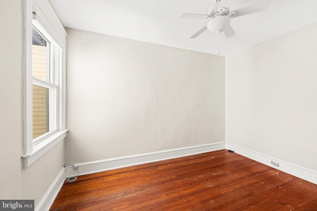 unfurnished room with baseboards, a ceiling fan, hardwood / wood-style floors, and plenty of natural light