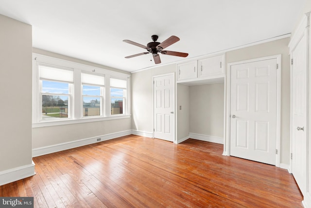 unfurnished bedroom featuring light wood-type flooring, baseboards, and ceiling fan