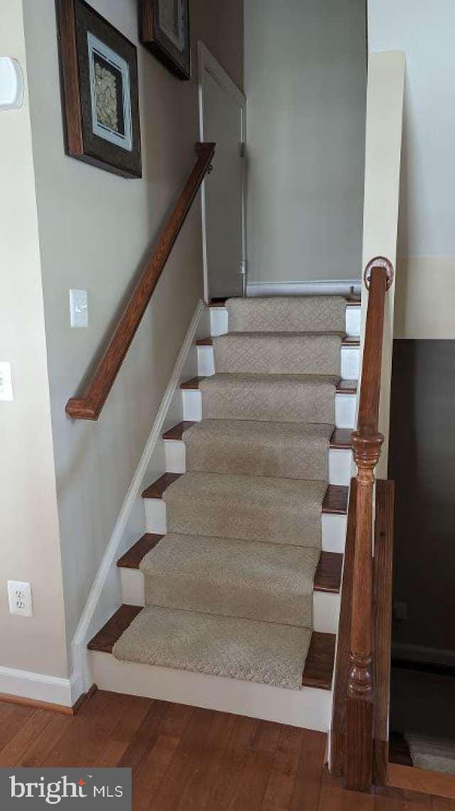 402 Village Center Blvd, Milton, DE 19968 - staircase featuring baseboards and wood finished floors