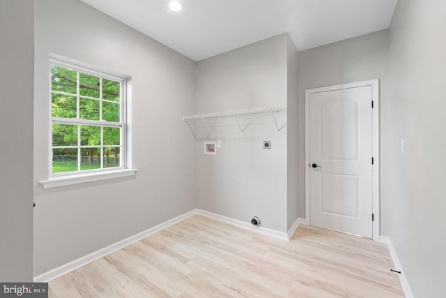 laundry area with electric dryer hookup, light wood-type flooring, hookup for a washing machine, and baseboards