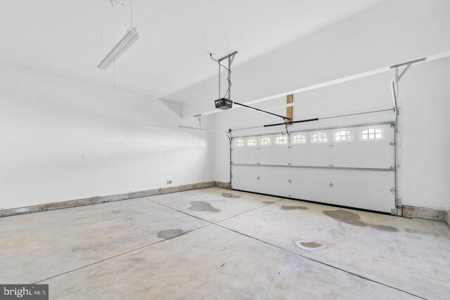garage featuring a garage door opener and baseboards