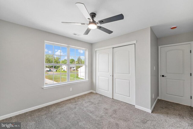 unfurnished bedroom with carpet, baseboards, a closet, and ceiling fan