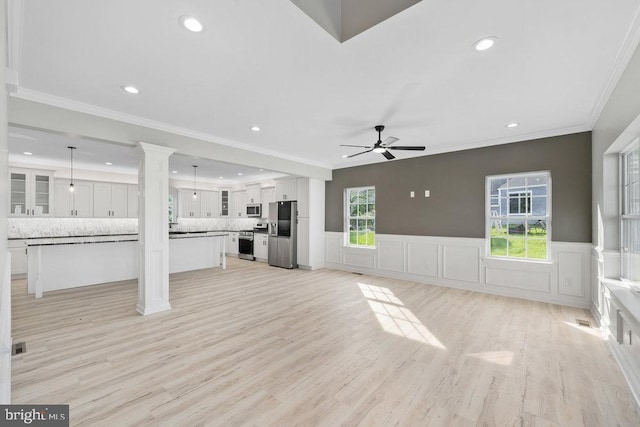 unfurnished living room featuring ceiling fan, recessed lighting, light wood-type flooring, wainscoting, and ornamental molding