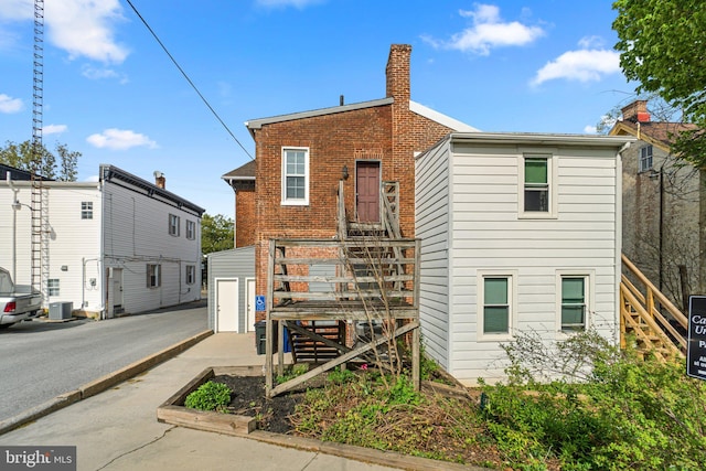 196 E Main St, Westminster, MD 21157 - view of front facade with central air condition unit, a chimney, stairway, and brick siding