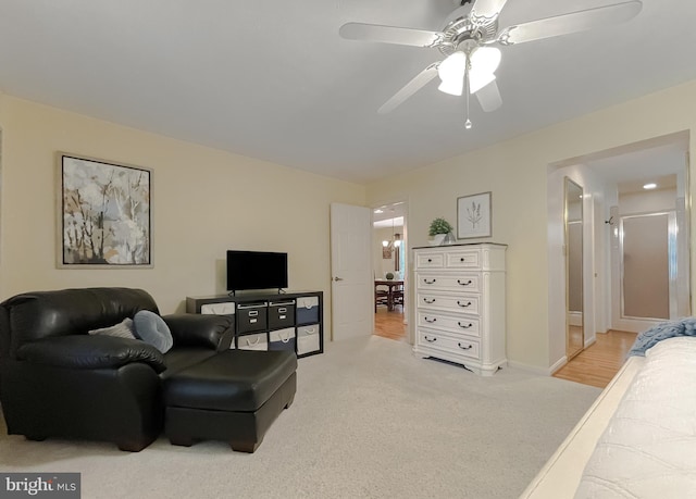 living room with carpet floors, baseboards, and ceiling fan