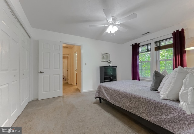 carpeted bedroom with baseboards, a ceiling fan, a closet, and visible vents